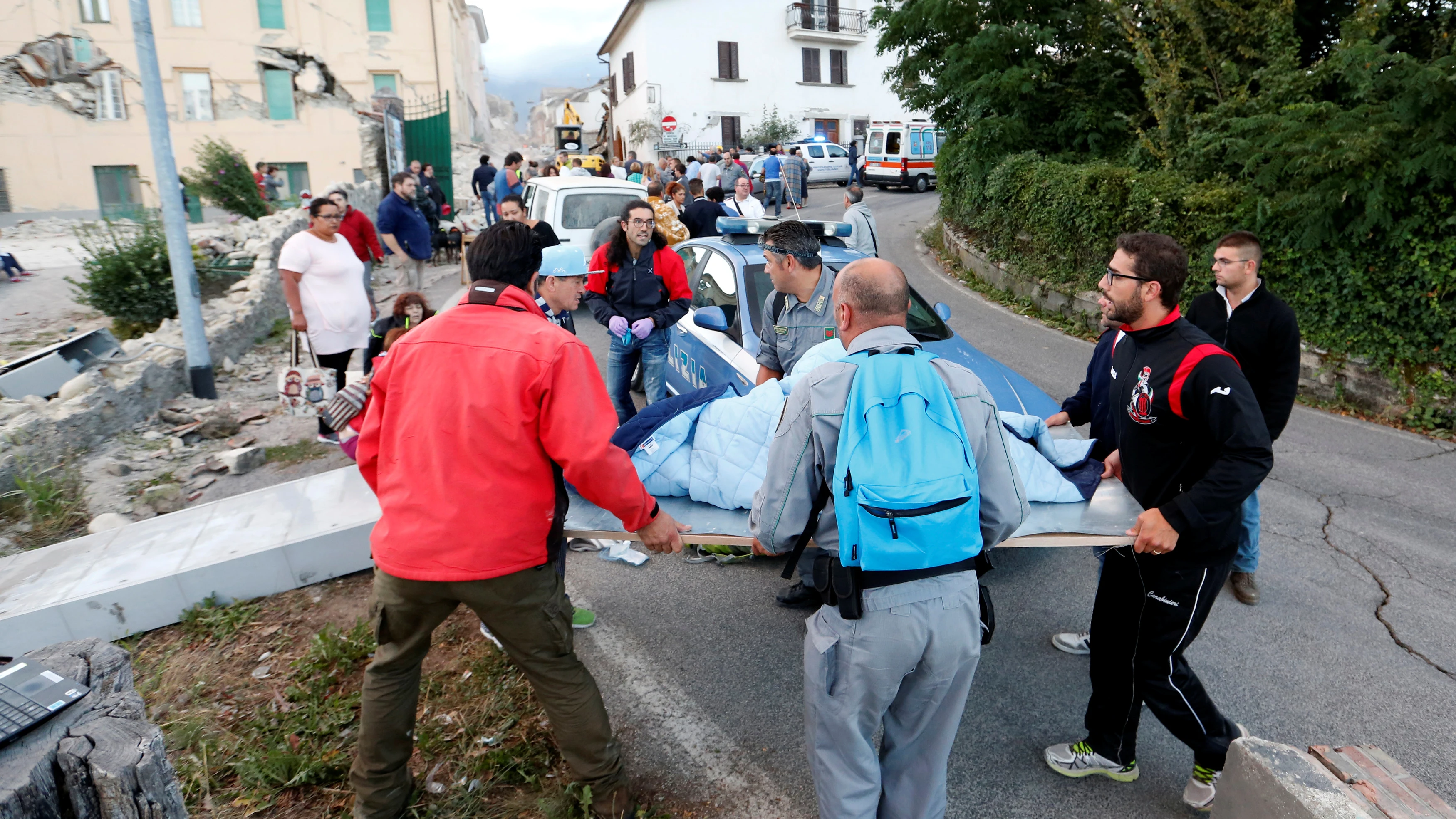 Los equipos de rescate llevan a una persona en una camilla tras el terremoto en Amatrice