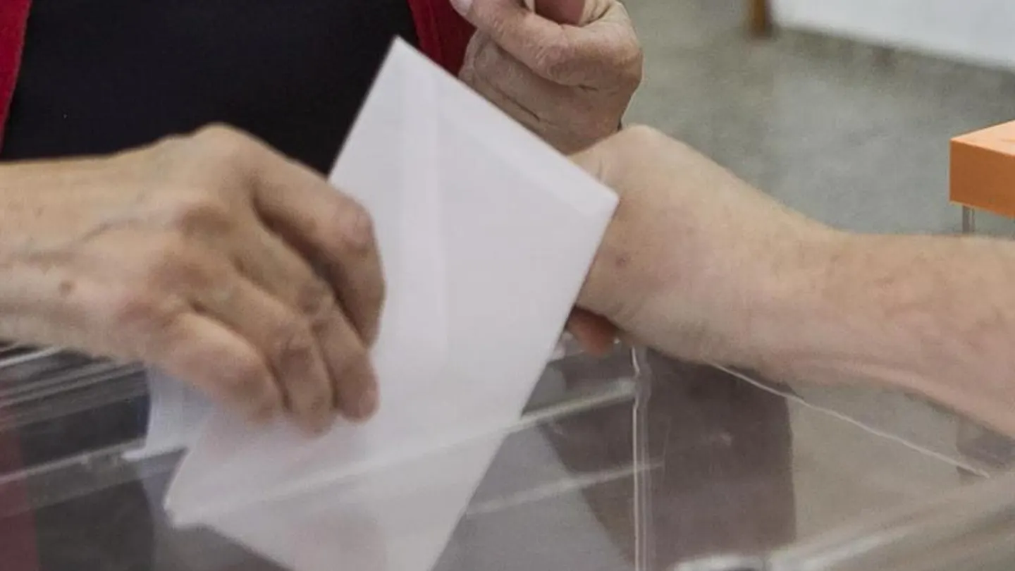 Una persona deposita su voto en unas elecciones Una persona deposita su voto en unas elecciones