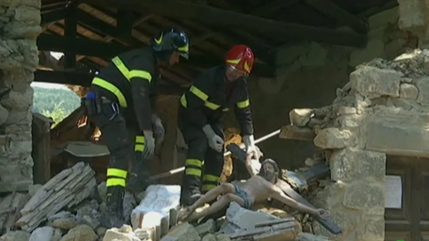 Dos bomberos sujetan una imagen de un cristo en Italia Dos bomberos sujetan una imagen de un cristo en Italia