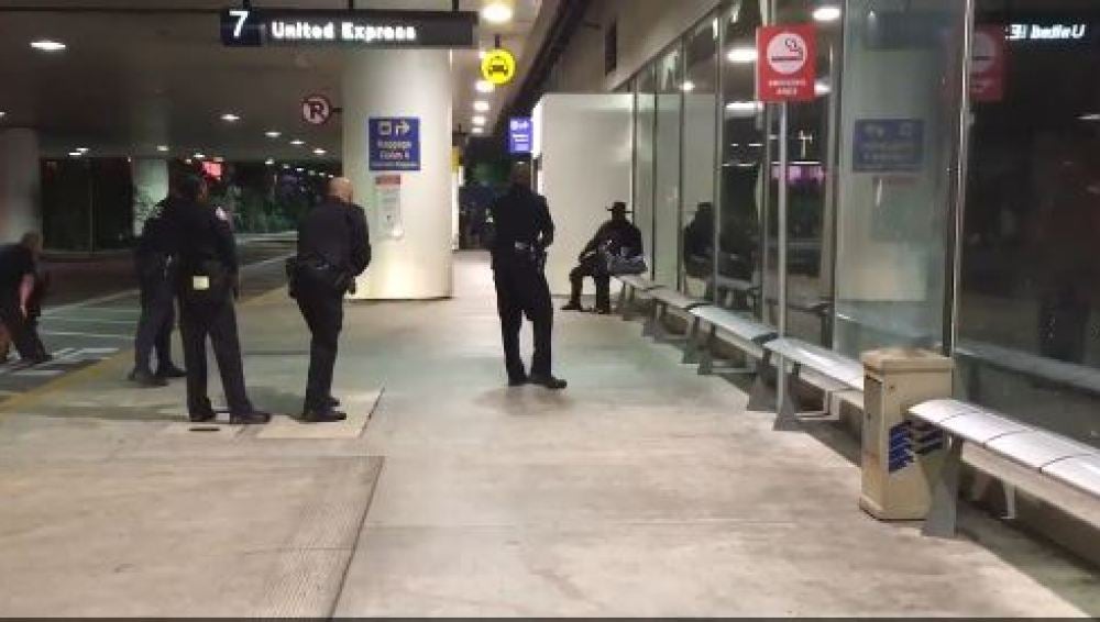 Varios agentes rodean a un individuo disfrazado de 'El Zorro' en el aeropuerto de Los Ángeles
