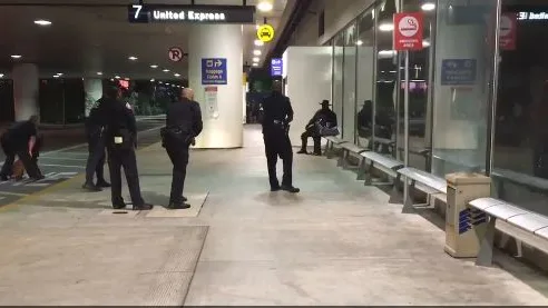 Varios agentes rodean a un individuo disfrazado de 'El Zorro' en el aeropuerto de Los Ángeles