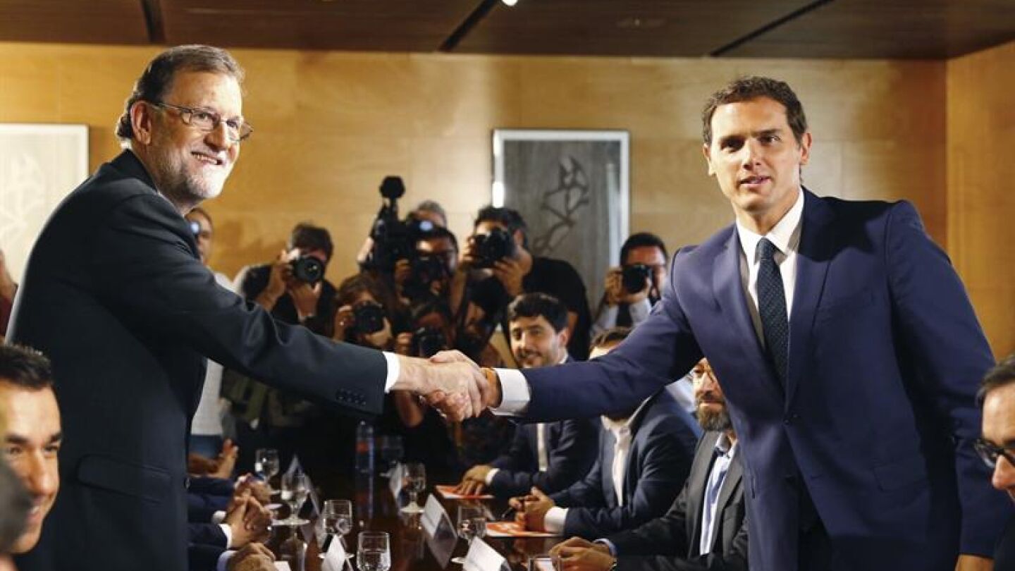  El jefe del Gobierno, Mariano Rajoy y el l&iacute;der de Ciudadanos, Albert Rivera, se estrechan la mano durante la reuni&oacute;n de sus respectivas delegaciones en la que van a certificar el acuerdo de investidura
