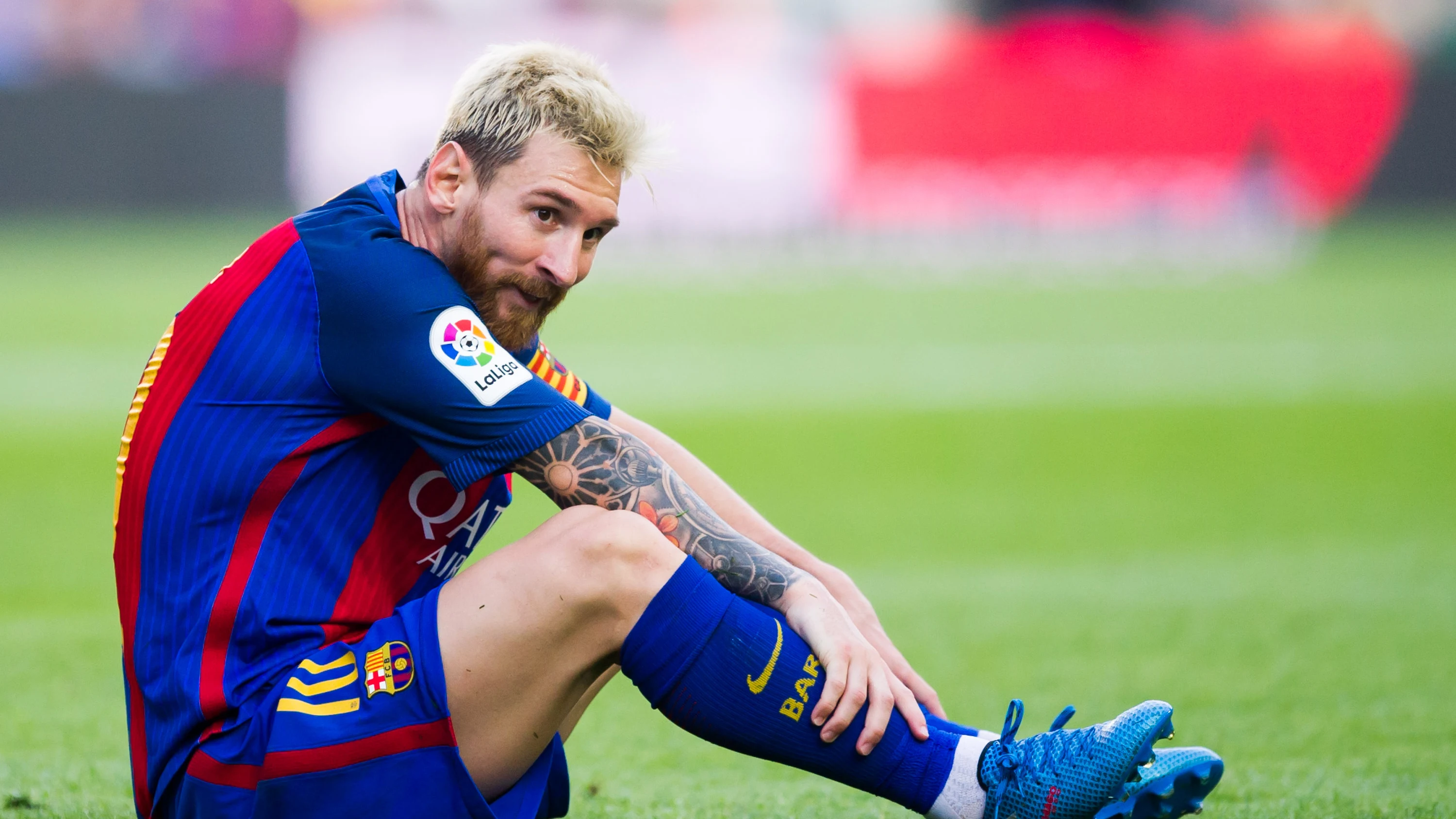 Messi, sentado en el c&eacute;sped durante un partido con el Bar&ccedil;a