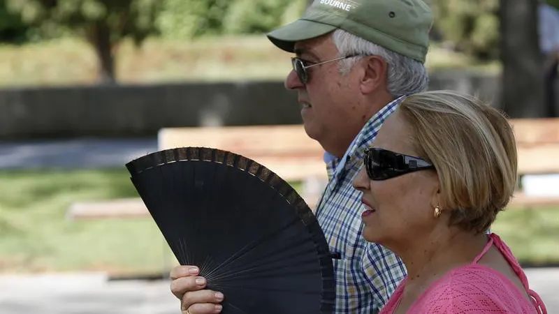 Dos se&ntilde;ores se abanican ante el calor