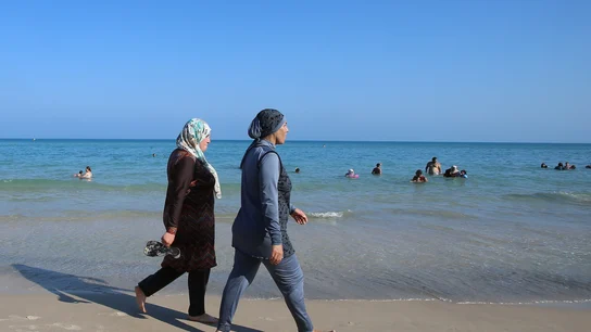 Dos mujeres vestidas con burkinis en una playa Dos mujeres vestidas con burkinis en una playa
