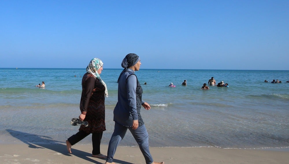 Dos mujeres vestidas con burkinis en una playa 