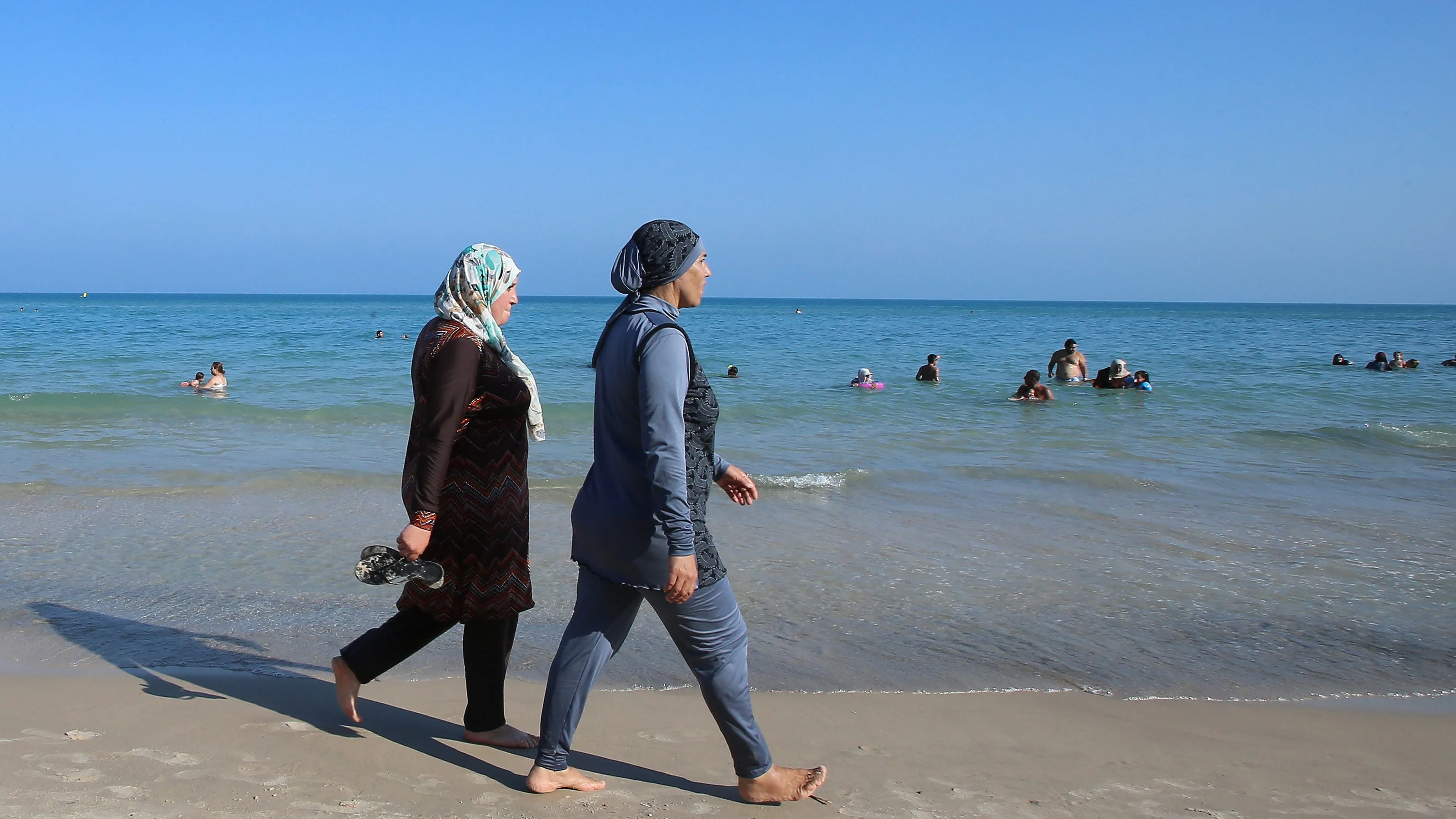 Dos mujeres vestidas con burkinis en una playa 