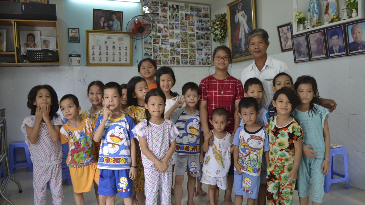 Tong Phuoc Phuc posa junto a varios de los ni&ntilde;os que cuida