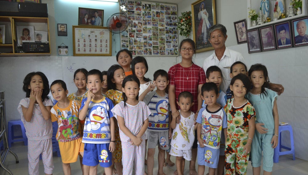 Tong Phuoc Phuc posa junto a varios de los niños que cuida