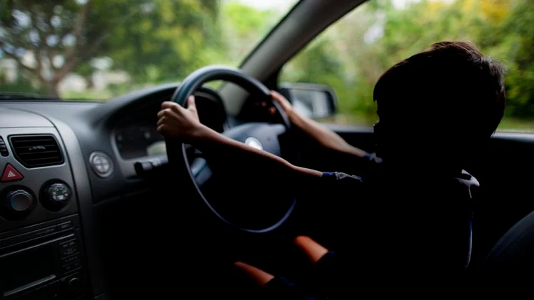 Un niño conduciendo un coche