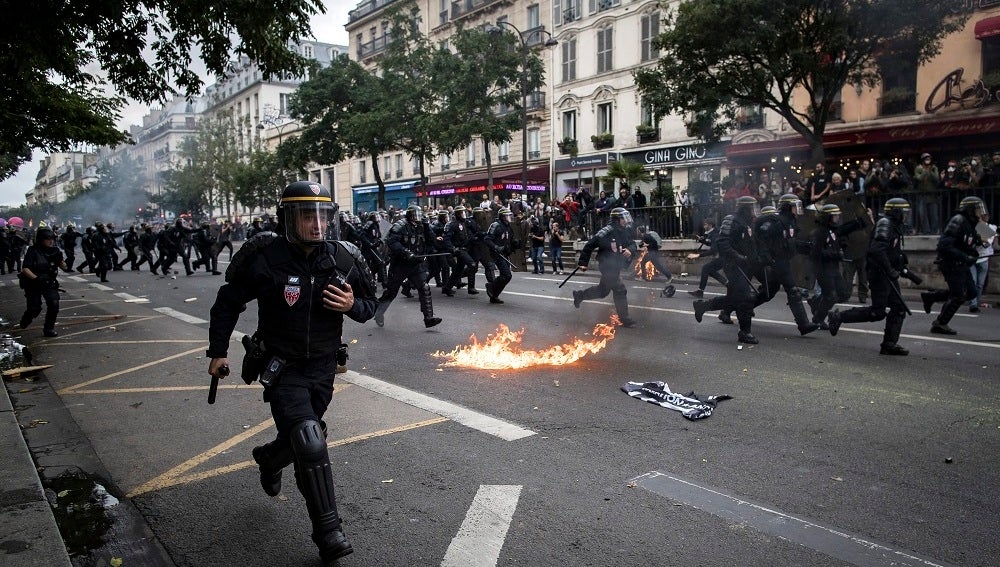 Varios policías persiguen a los manifestantes durante una manifestación contra la nueva reforma laboral en París, Francia.