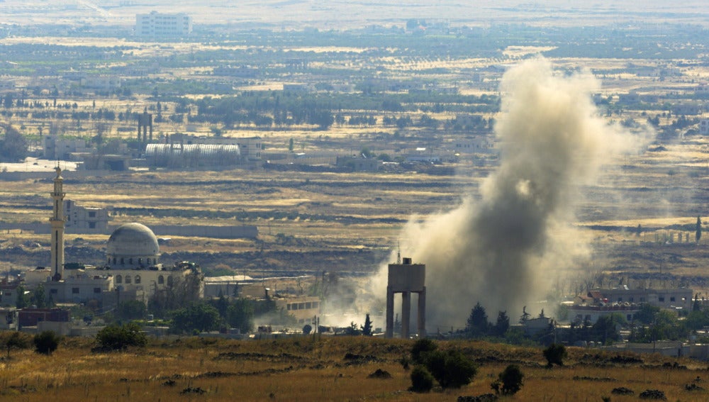 Una columna de humo se eleva en el aire tras una explosión en el lado sirio de la frontera con Israel, en la provincia de Al Quneitra.