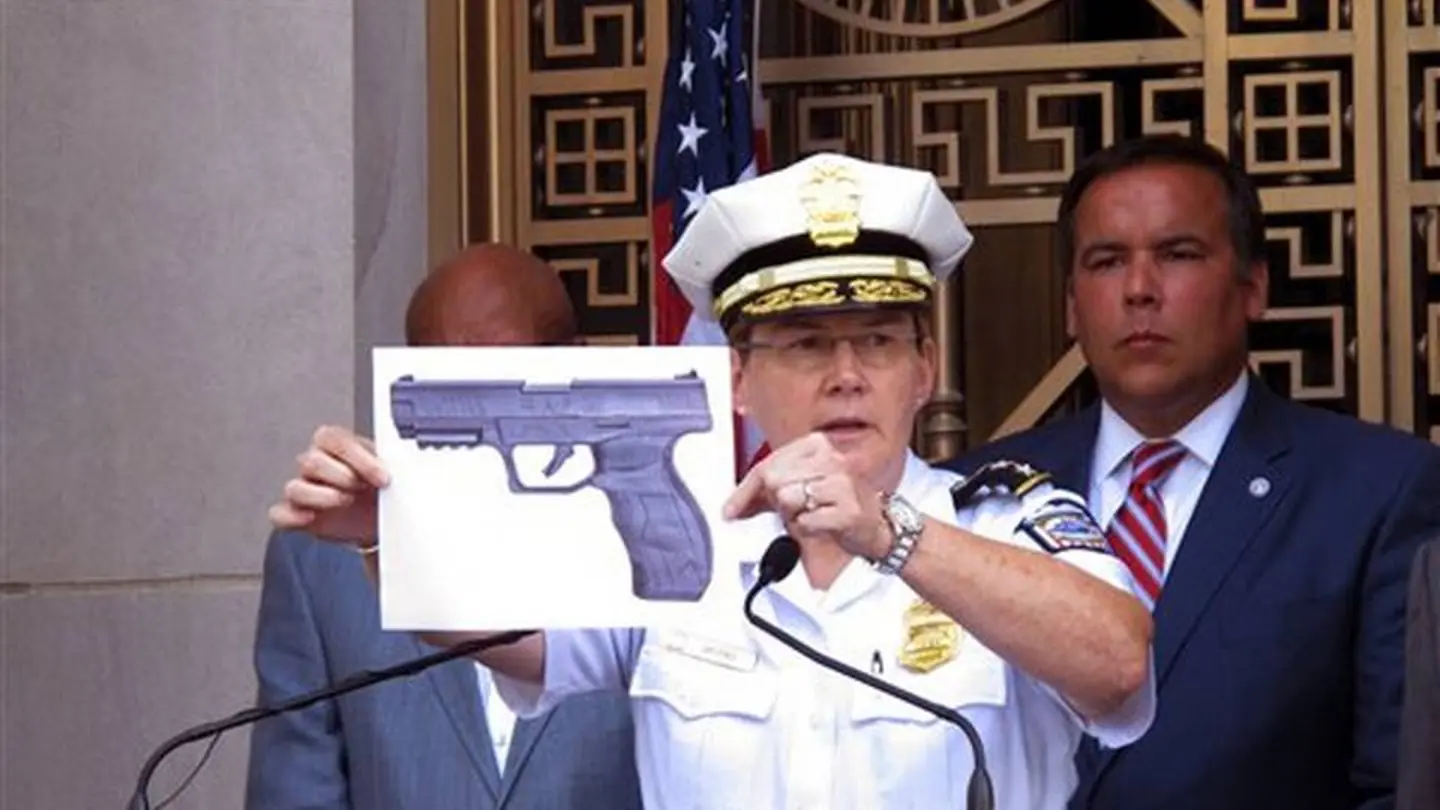 Un agente muestra una imagen de la pistola de balines que llevaba King Un agente muestra una imagen de la pistola de balines que llevaba King