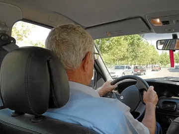 Un hombre mayor conduciendo Un hombre mayor conduciendo