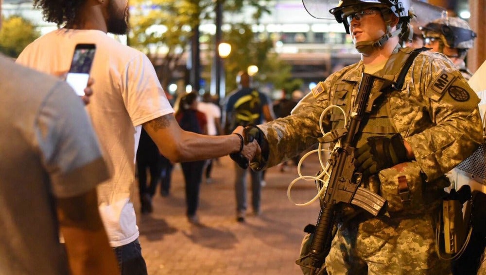 Un manifestante saluda a un efectivo de la Guardia Nacional 