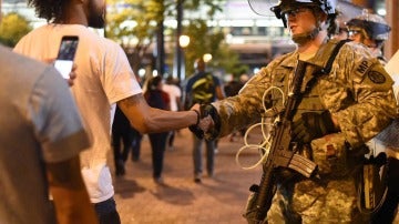 Un manifestante saluda a un efectivo de la Guardia Nacional 