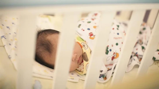 Un bebé en una cuna Un bebé en una cuna
