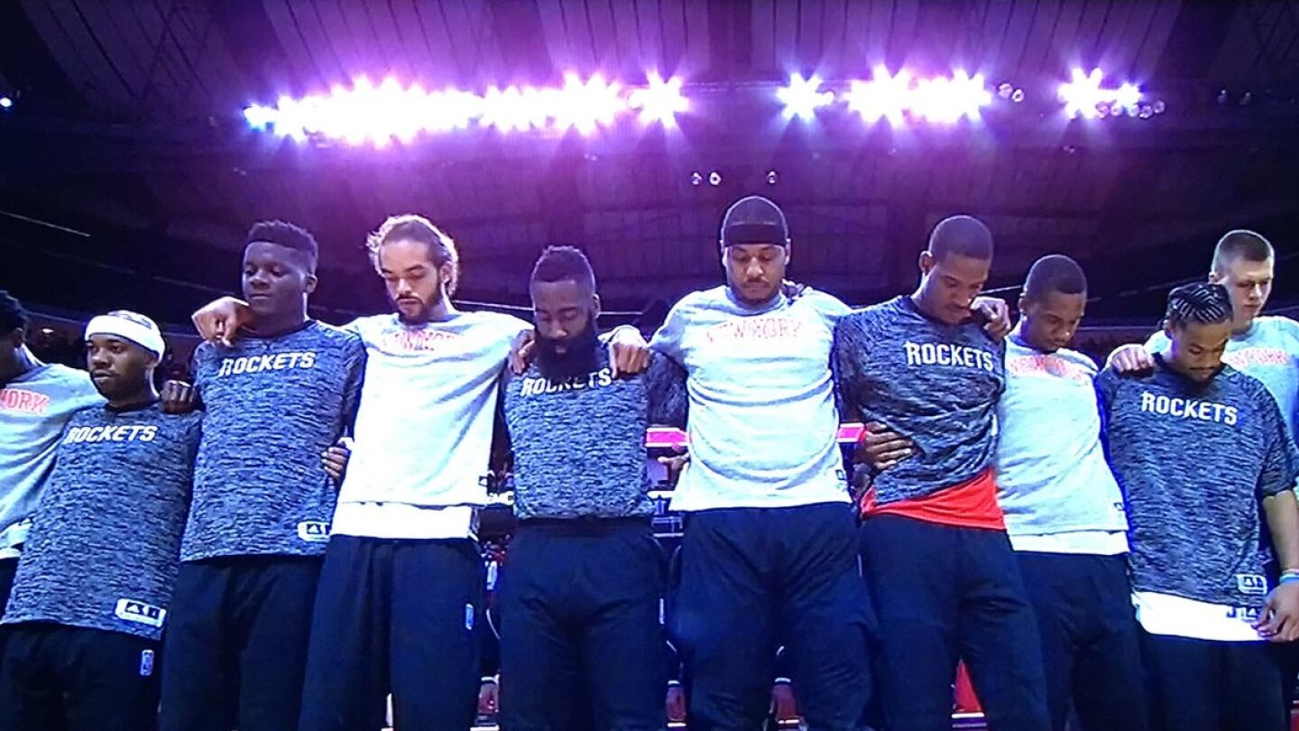 Los jugadores de los Knicks y de los Rockets, unidos durante el himno de Estados Unidos