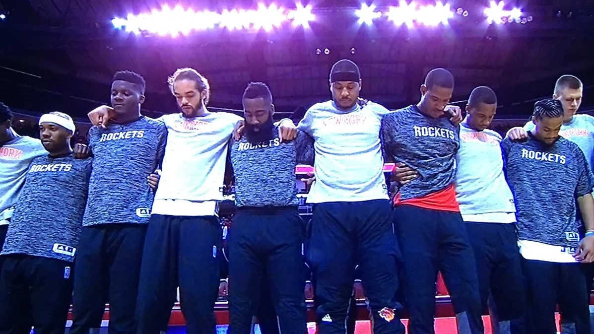 Los jugadores de los Knicks y de los Rockets, unidos durante el himno de Estados Unidos