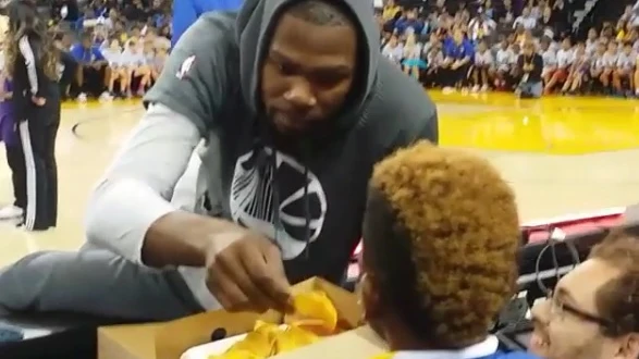 Kevin Durant coge nachos a un niño en el Oracle Arena