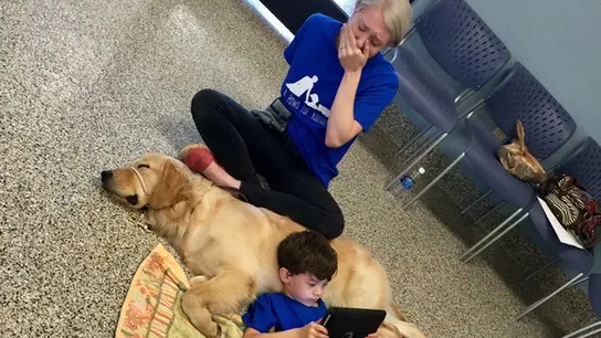 Un niño autista se tumba con su perro Un niño autista se tumba con su perro