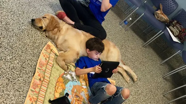 Un niño autista se tumba con su perro