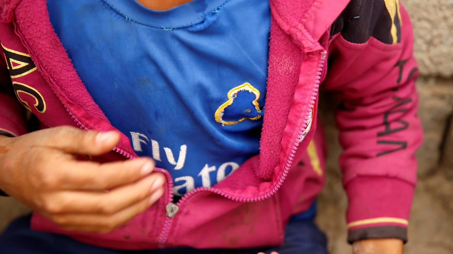 Un niño muestra su camiseta del Real Madrid con el escudo arrancado Un niño muestra su camiseta del Real Madrid con el escudo arrancado