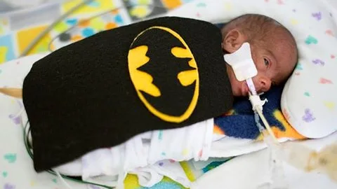 Uno de los bebés con un disfraz de Batman