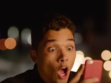Joven asombrado mirando un mensaje de WhatsApp Joven asombrado mirando un mensaje de WhatsApp