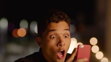 Joven asombrado mirando un mensaje de WhatsApp
