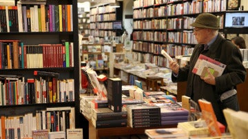 Un hombre mira un libro en una librería