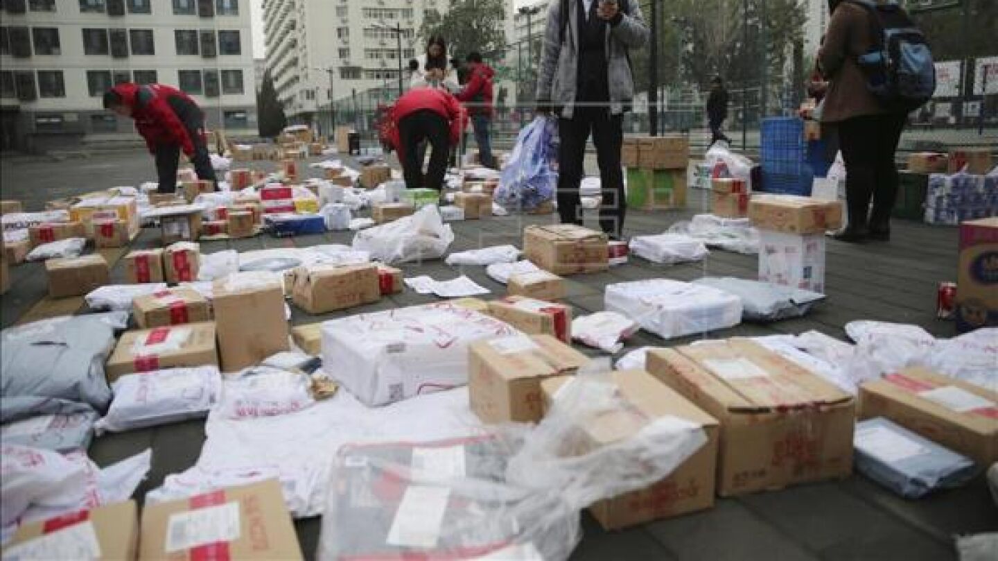 Consumidores buscan sus paquetes a las puertas de JD.com, una tienda electronica,