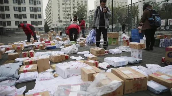 Consumidores buscan sus paquetes a las puertas de JD.com, una tienda electronica,