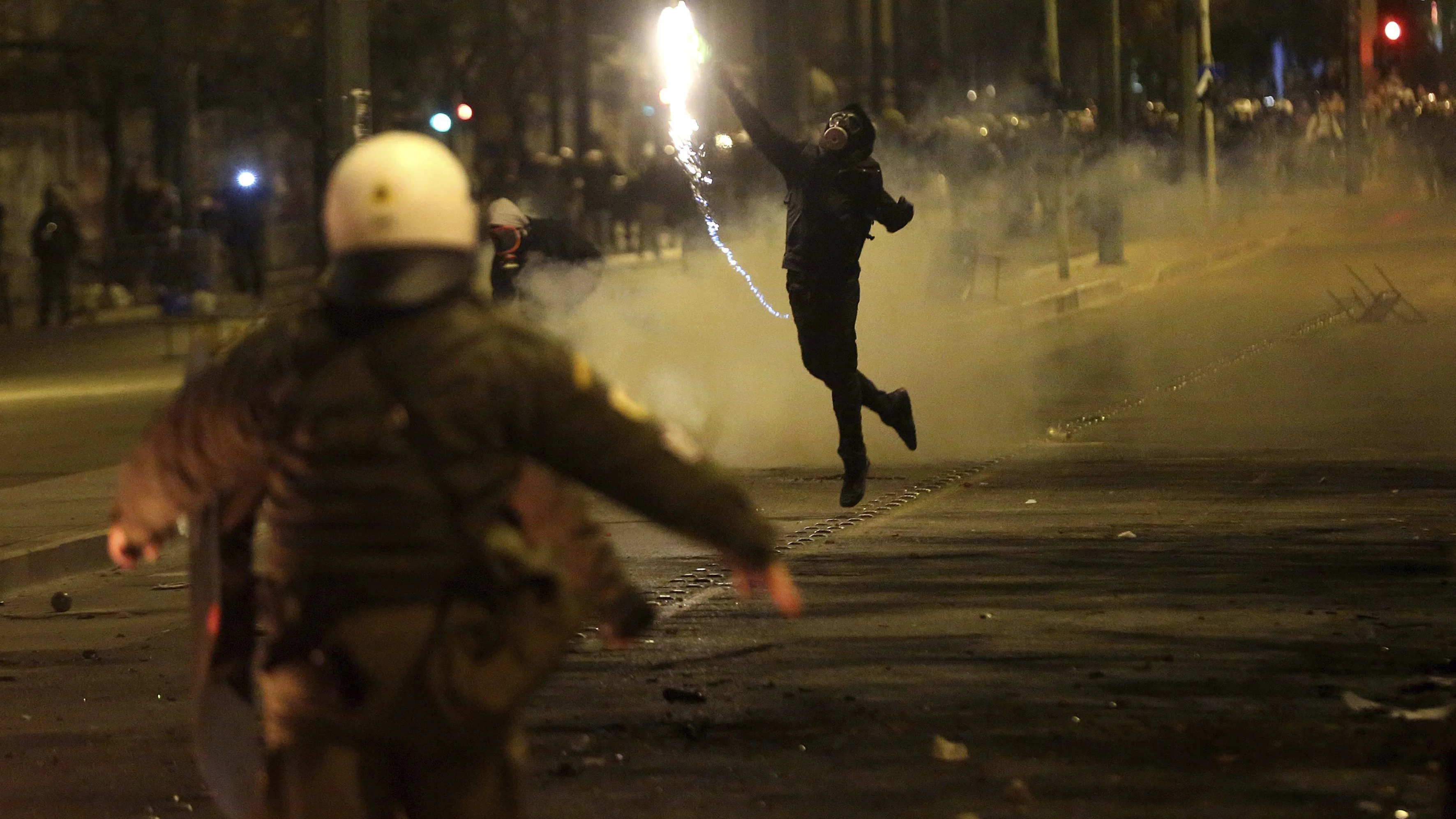 Un manifestante lanza un cóctel molotov contra los policías en Atenas