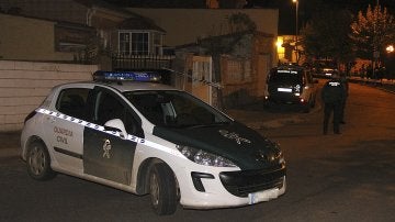 Un coche de la Guardia Civil junto a la vivienda donde se encontraron los cuerpos