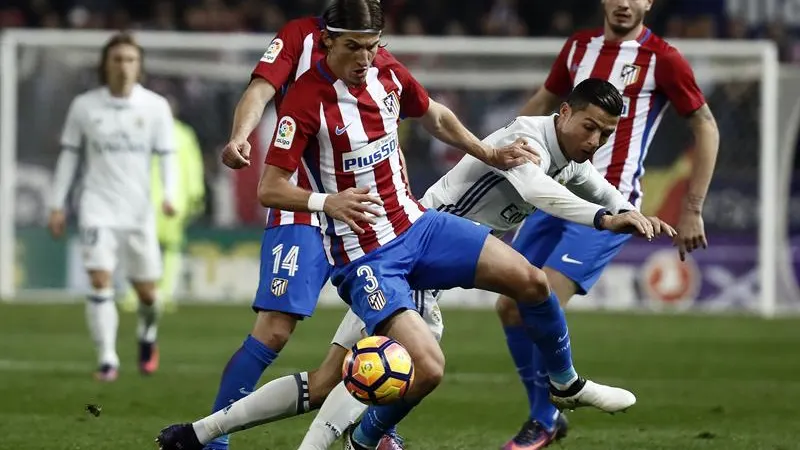 El portugu&eacute;s Cristiano Ronaldo (d), del Real Madrid, lucha el bal&oacute;n con el defensa brasiel&ntilde;o del Atl&eacute;tico de Madrid Filipe Luis