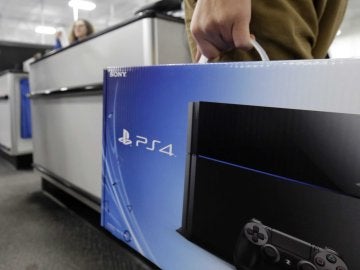 Imagen de archivo de un cliente sujetando una PlayStation 4 Imagen de archivo de un cliente sujetando una PlayStation 4