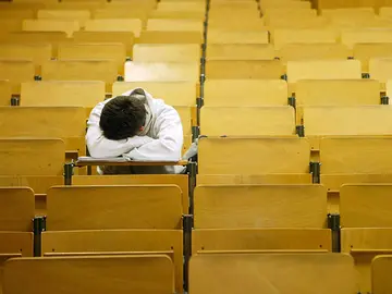 Un universitario durmiendo en el aula Un universitario durmiendo en el aula