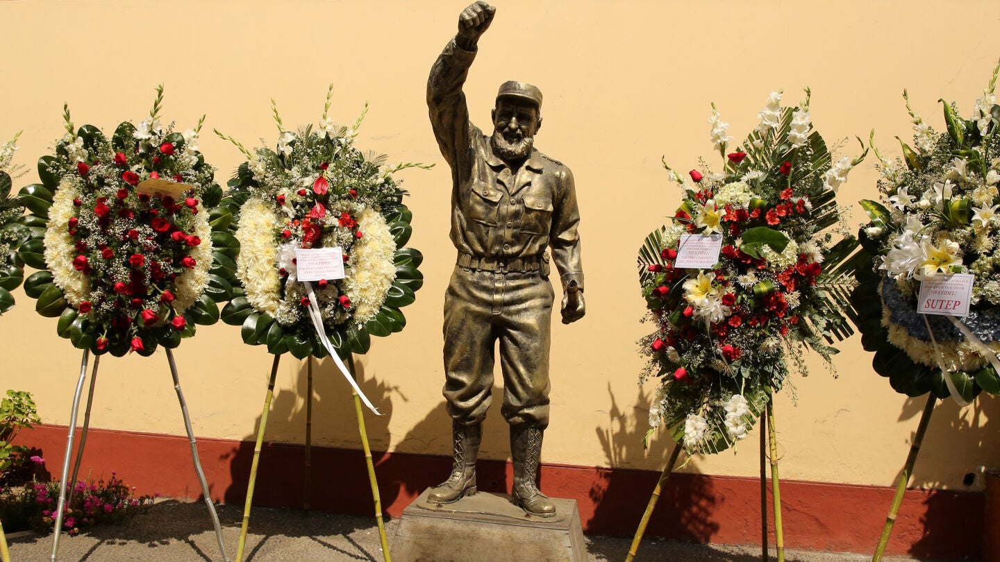Flores junto a la estatua de Fidel Castro en la Embajada de Cuba en Lima