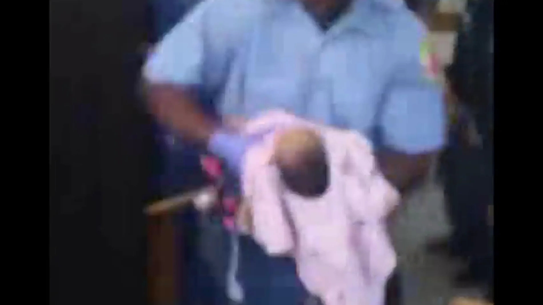 Frame 26.302079 de: Un policía intenta salvar sin éxito a una bebe de un mes durante una protesta