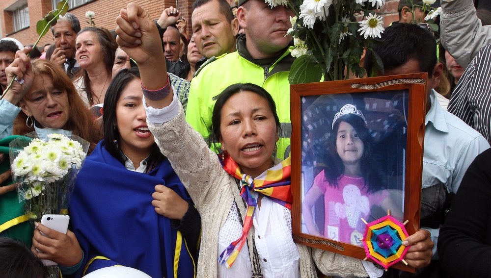 Una mujer sostiene una fotografía de la pequeña asesinada Yuliana Andrea Sambon