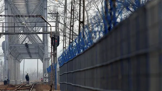 Un policía fronterizo inspecciona una vía de tren Un policía fronterizo inspecciona una vía de tren