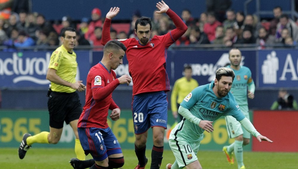 Leo Messi recibe una falta contra Osasuna