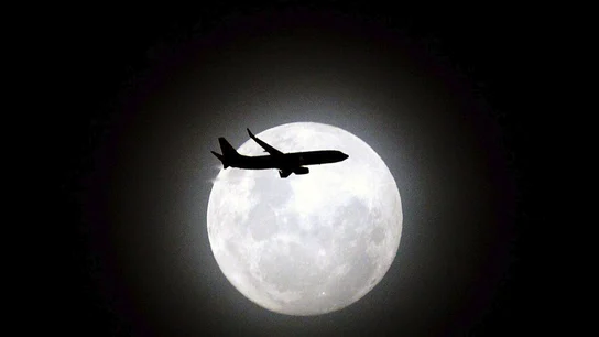 Superluna en Sídney (13-12-2016) Un avión de pasajeros pasa delante de la tercera y última luna en perigeo sobre la playa de Maroubra en Sídney (Australia)