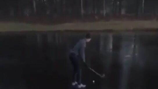Intenta sacar una pelota de golf de un lago helado 