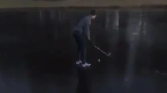 Intenta sacar una pelota de golf de un lago helado 