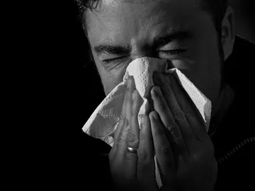 Un hombre sonándose la nariz Un hombre sonándose la nariz