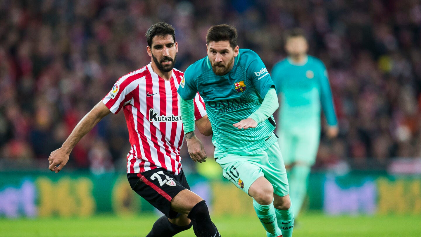 Messi conduce el bal&oacute;n mientras Ra&uacute;l Garc&iacute;a intenta rob&aacute;rselo