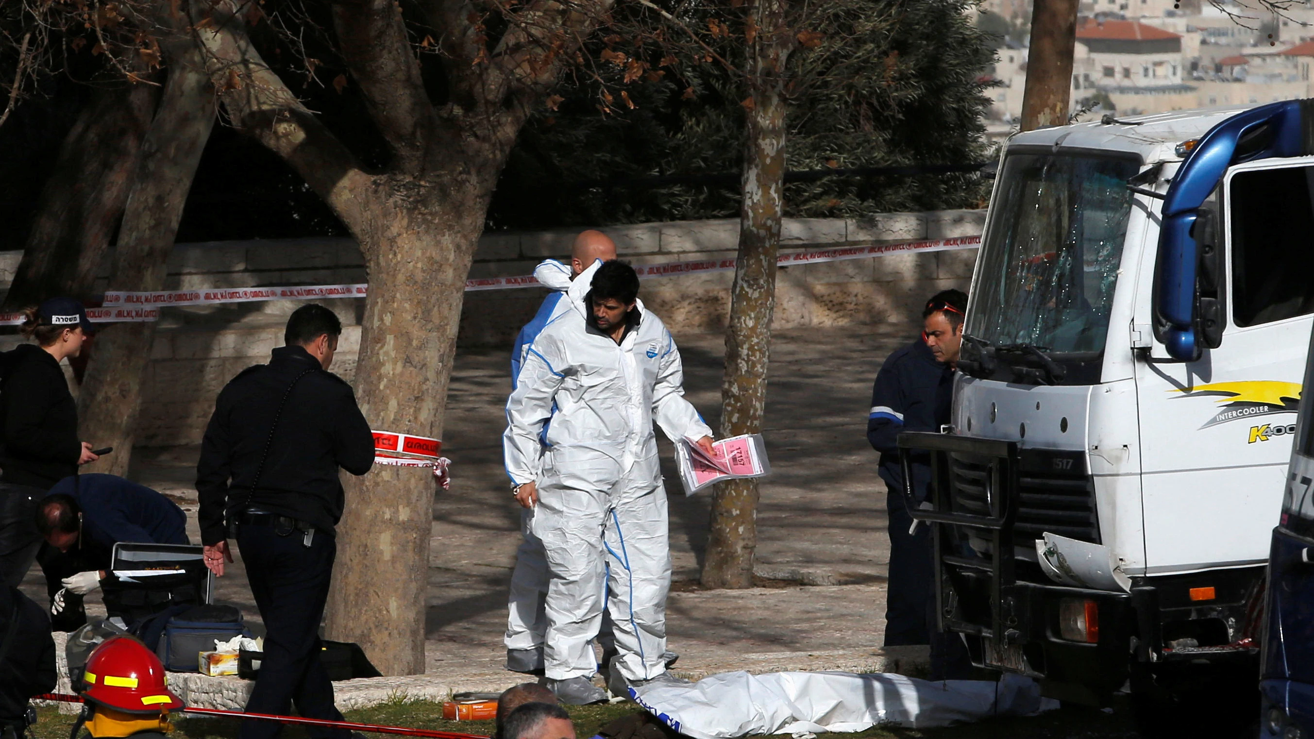 Las fuerzas israelíes trabajan en el lugar donde el camión a irrumpido causando muertos y heridos en Jerusalén