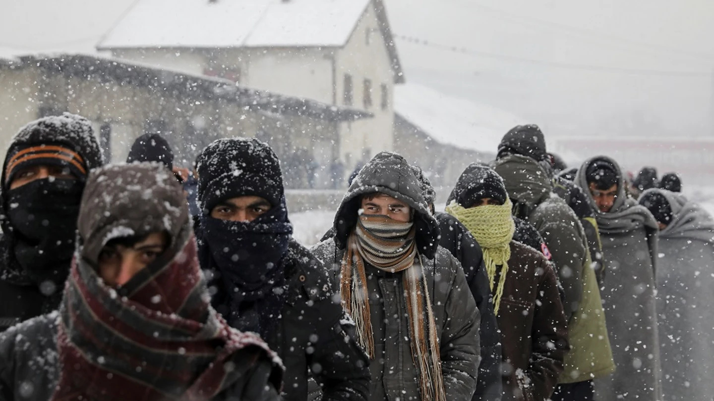 Migrantes esperan en fila para recibir comida fuera de un almacén abandonado en Belgrado Migrantes esperan en fila para recibir comida fuera de un almacén abandonado en Belgrado
